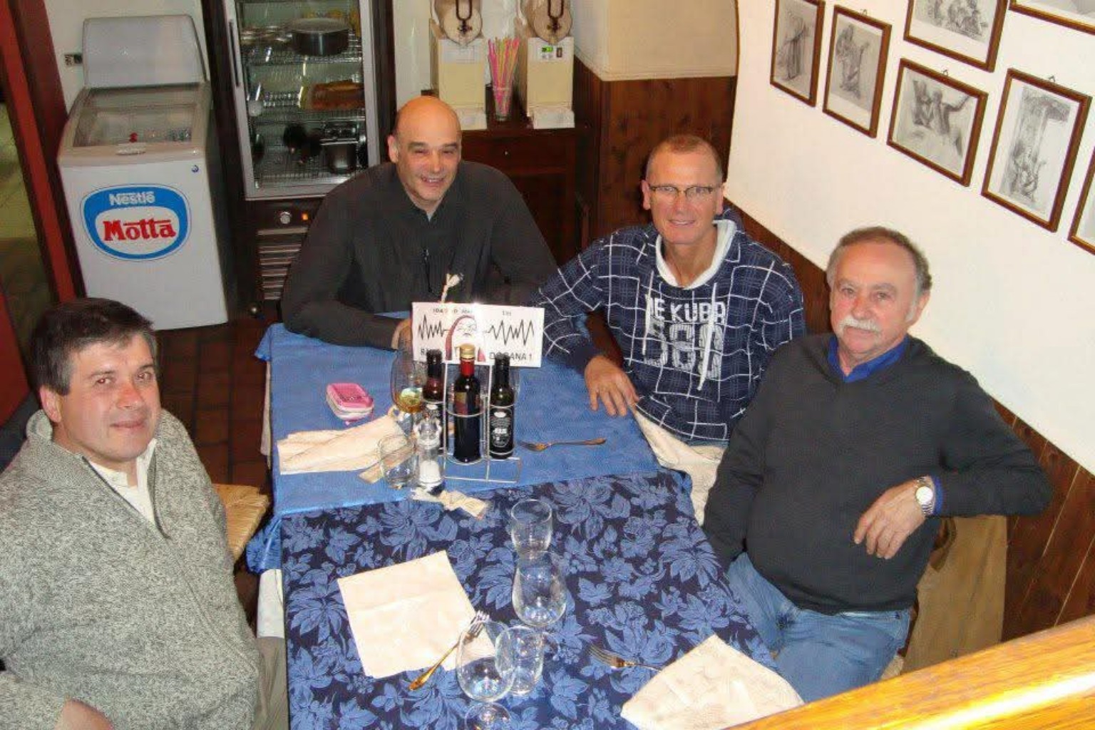 Fondatori Radio Dogana 1 riuniti al tavolo con logo RD1